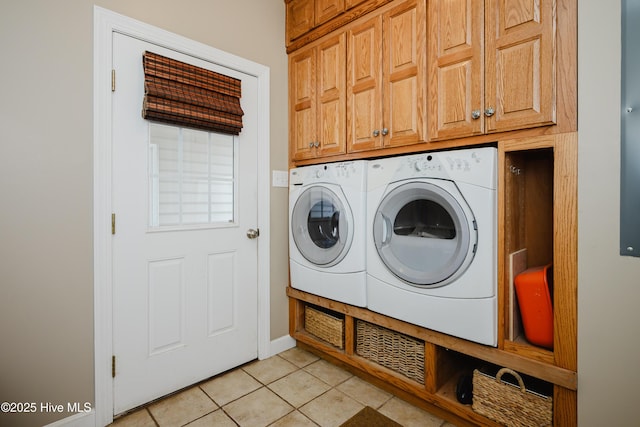 laundry area with cabinet space, washer and clothes dryer, and light tile patterned floors