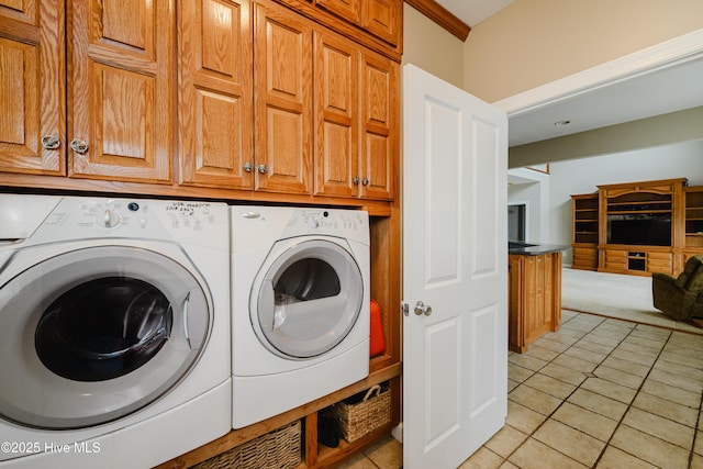 laundry area with cabinet space, independent washer and dryer, and light tile patterned floors