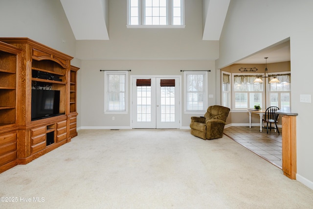 living room with carpet floors, french doors, high vaulted ceiling, and baseboards