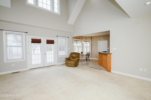 living area with french doors, carpet, a wealth of natural light, and baseboards