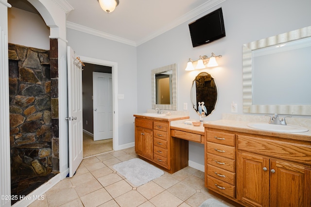 bathroom with crown molding, vanity, tile patterned flooring, tiled shower, and baseboards