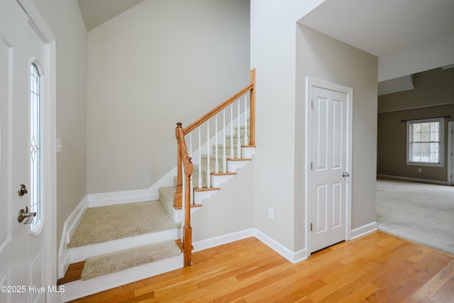 foyer with stairway, baseboards, and wood finished floors