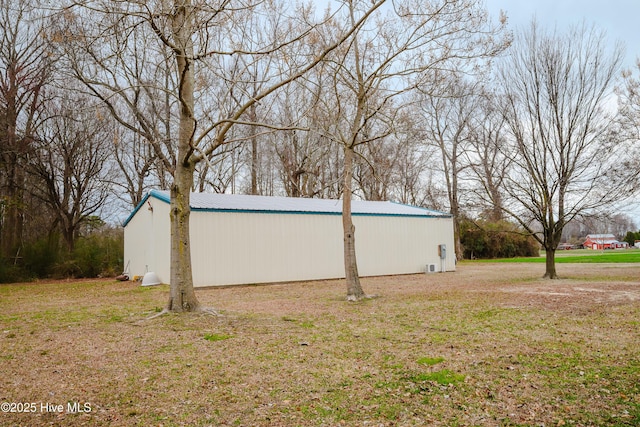 view of side of home featuring an outbuilding and a yard