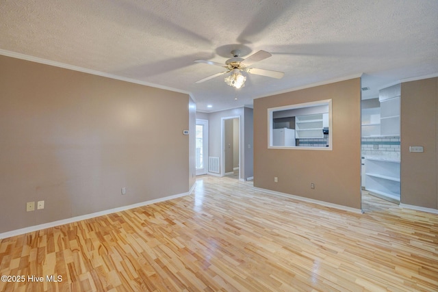 empty room with ornamental molding, wood finished floors, and a textured ceiling