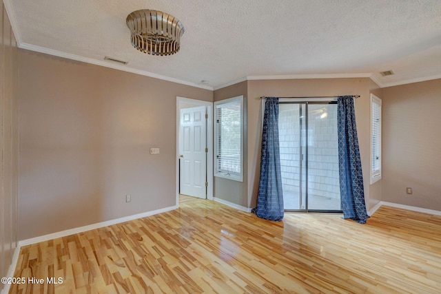 unfurnished room featuring visible vents, baseboards, light wood finished floors, ornamental molding, and a textured ceiling