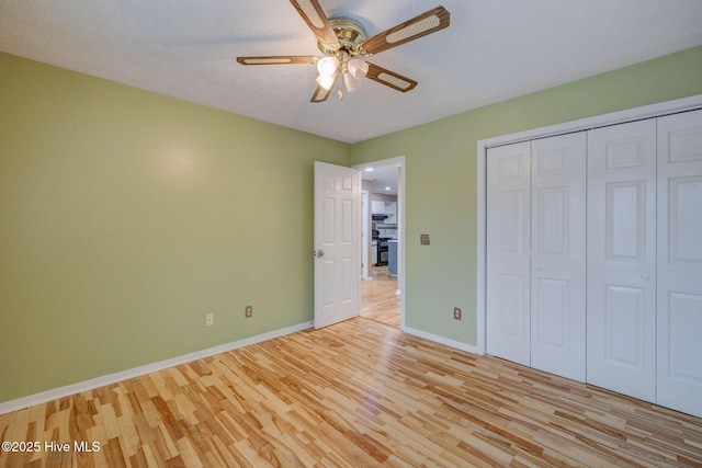 unfurnished bedroom with baseboards, light wood-type flooring, a closet, and ceiling fan