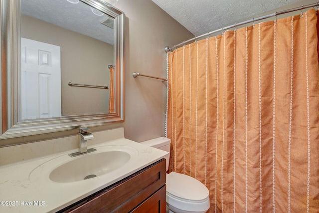 bathroom with toilet, a textured ceiling, and vanity