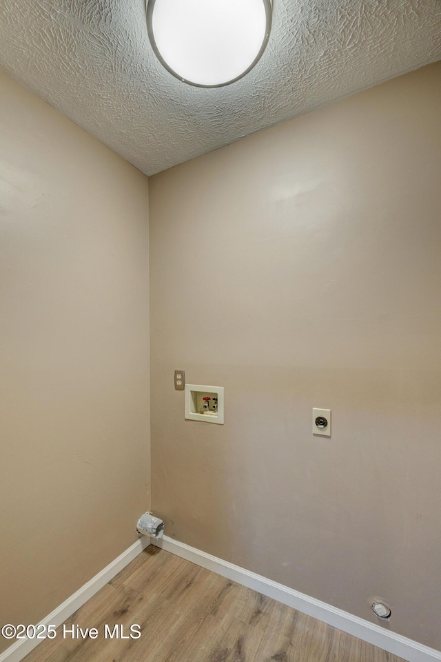 washroom with wood finished floors, baseboards, hookup for an electric dryer, hookup for a washing machine, and laundry area