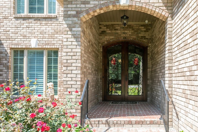 doorway to property featuring french doors and brick siding