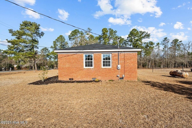 view of home's exterior featuring crawl space, a lawn, and brick siding