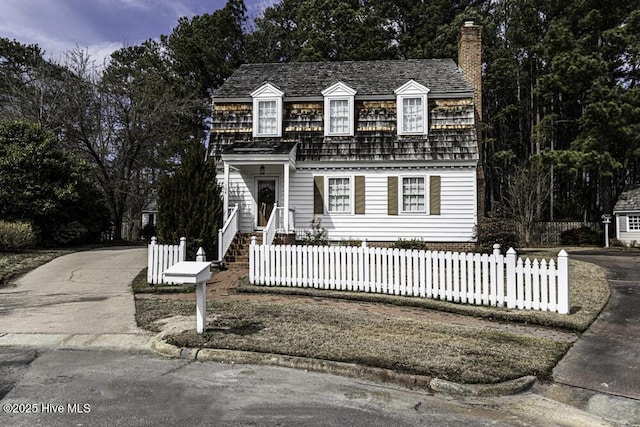 view of front of house with a fenced front yard and a chimney