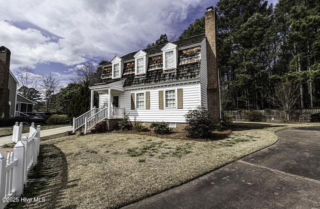 dutch colonial with fence and a chimney