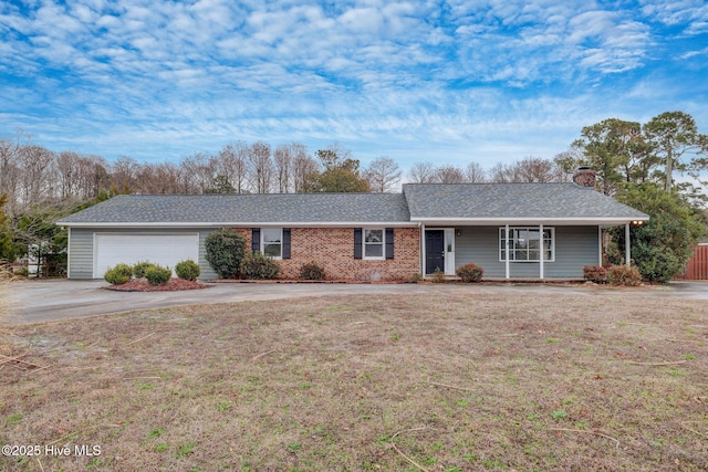 single story home with a chimney, an attached garage, and a front yard