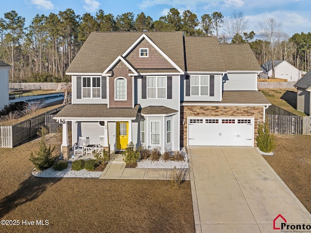 view of front of house with a garage, fence, driveway, and a shingled roof