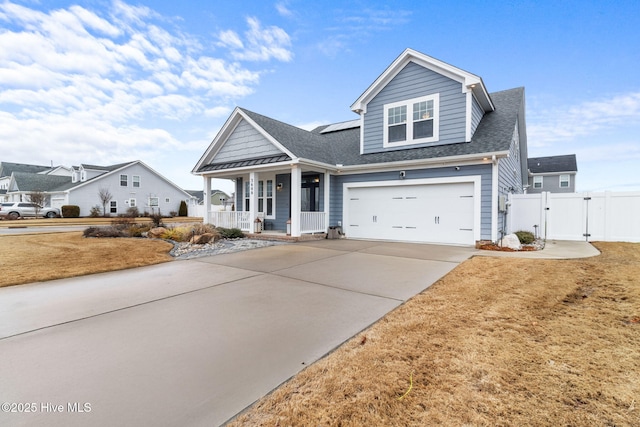 view of front facade featuring a porch, an attached garage, a shingled roof, concrete driveway, and a gate