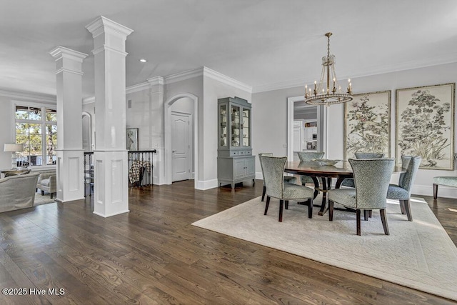 dining room with dark wood-style floors, ornamental molding, and ornate columns