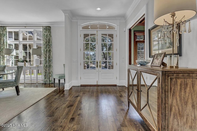 foyer entrance featuring ornamental molding, french doors, dark wood-style flooring, and a healthy amount of sunlight