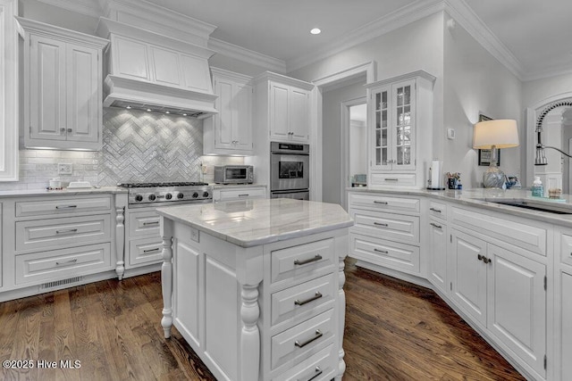 kitchen with premium range hood, glass insert cabinets, and white cabinetry