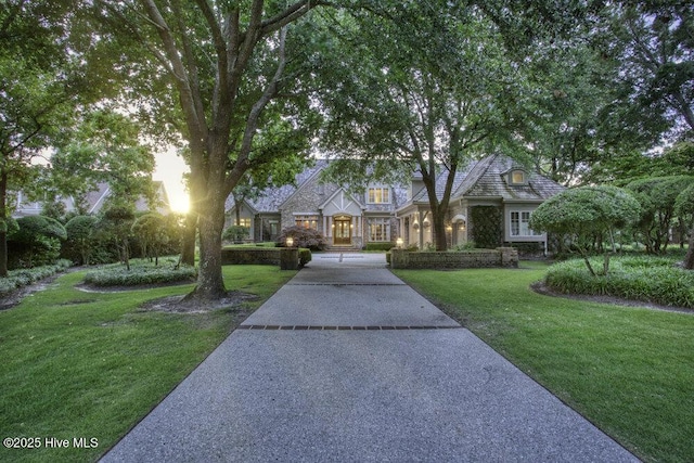 view of front of home with stone siding and a front lawn