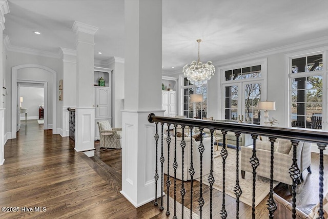 hallway featuring arched walkways, dark wood-style flooring, a notable chandelier, recessed lighting, and ornamental molding