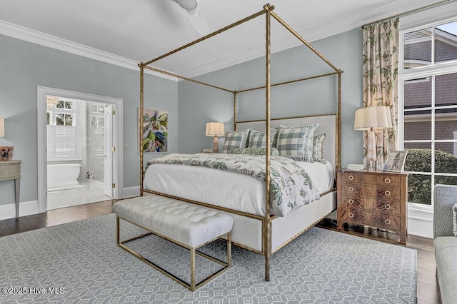 bedroom with ornamental molding, ensuite bath, wood finished floors, and baseboards