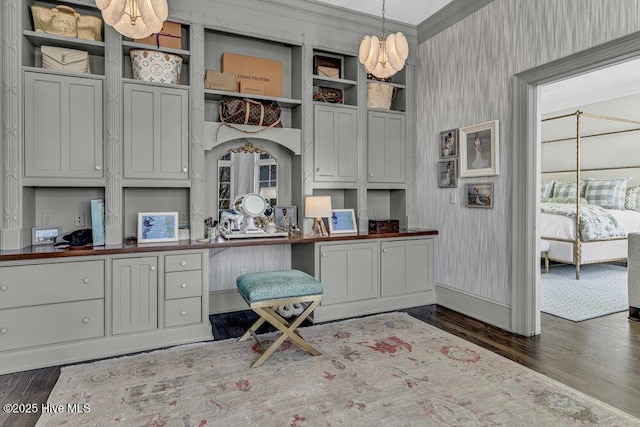 kitchen featuring dark wood-style floors, pendant lighting, crown molding, and wallpapered walls