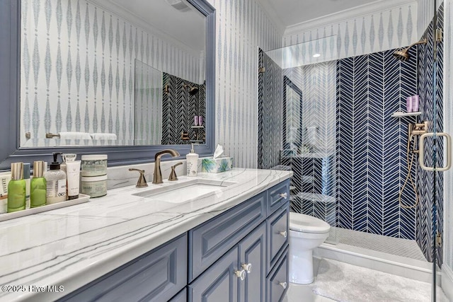 bathroom with a stall shower, vanity, toilet, and wallpapered walls