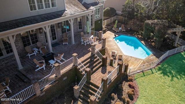 community pool with a patio and fence