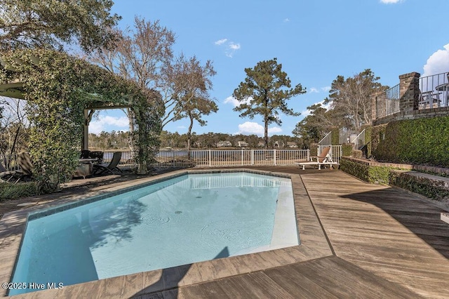 view of swimming pool with a wooden deck, a fenced in pool, and fence