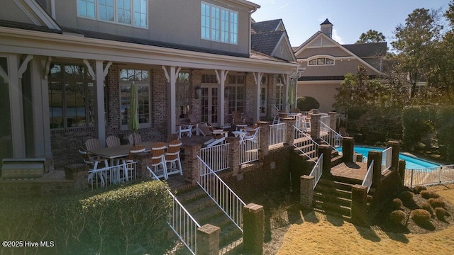 view of patio / terrace with stairway and a fenced in pool