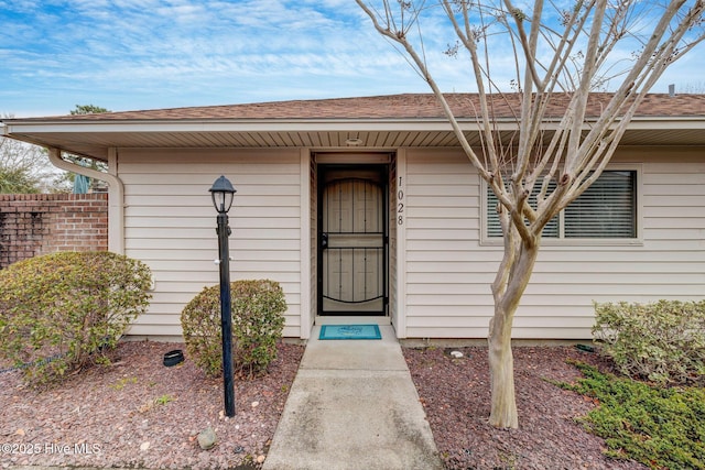 entrance to property with a shingled roof