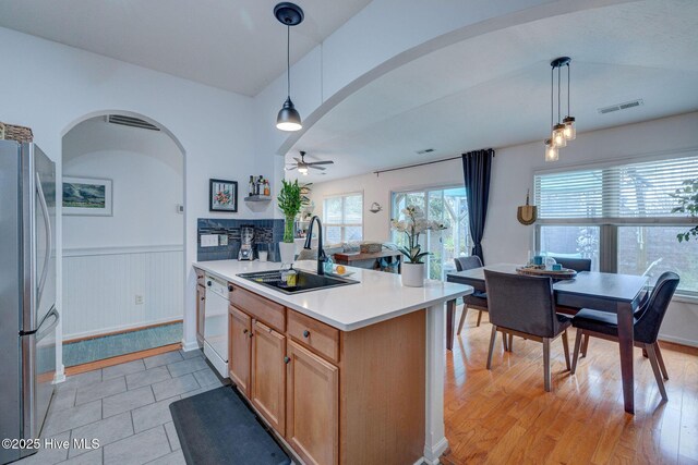 kitchen with arched walkways, white appliances, and light countertops