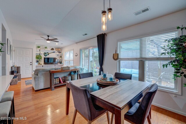 kitchen featuring a sink, light countertops, freestanding refrigerator, dishwasher, and decorative light fixtures