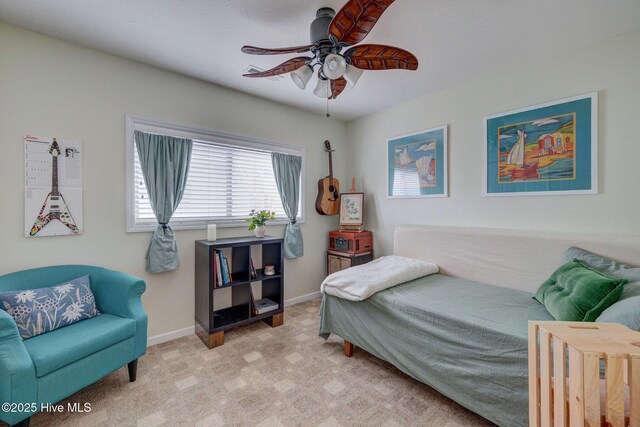 bedroom with ensuite bathroom, light carpet, wainscoting, and a ceiling fan