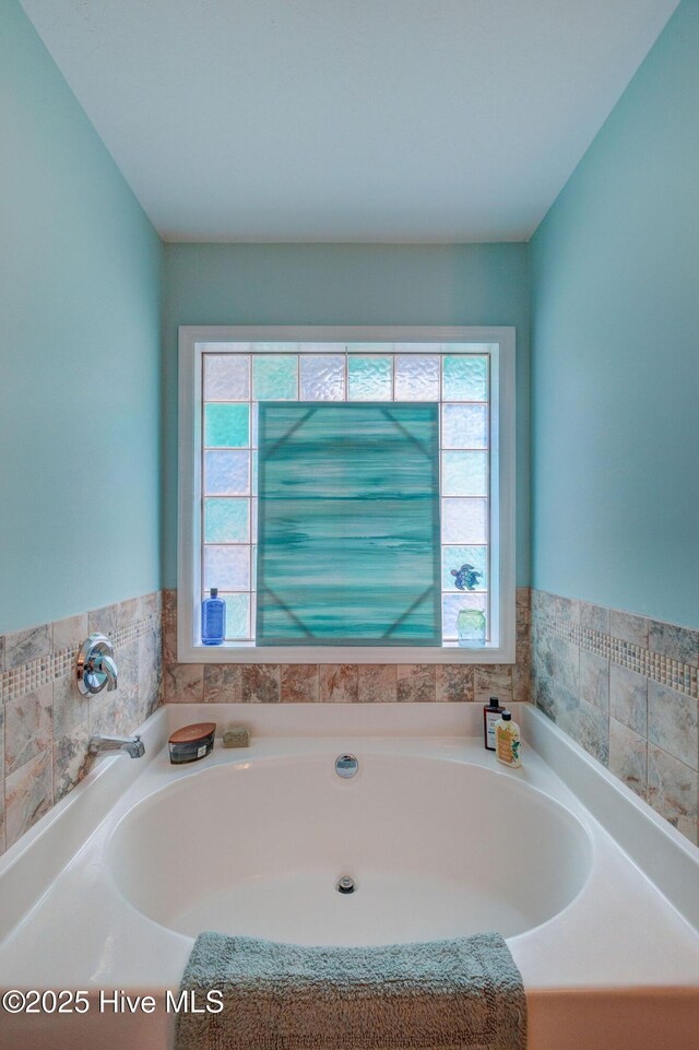 full bath with wainscoting, toilet, tile patterned floors, vanity, and a bath