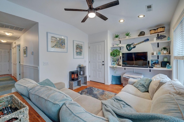 living room with lofted ceiling, ceiling fan, light wood finished floors, and visible vents