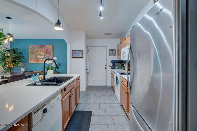 kitchen with pendant lighting, light countertops, visible vents, a sink, and white appliances