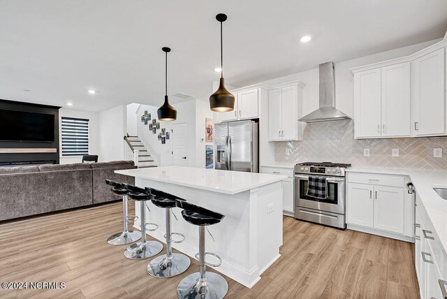 workout area featuring a ceiling fan, visible vents, light wood-style flooring, and baseboards