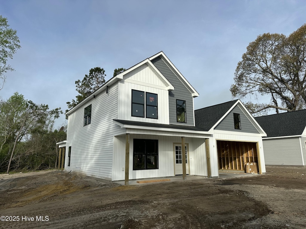 modern farmhouse style home with board and batten siding, driveway, and an attached garage