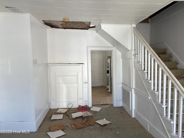 staircase featuring visible vents and a decorative wall