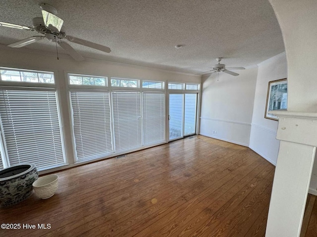 unfurnished living room with ornamental molding, ceiling fan, a textured ceiling, and wood finished floors