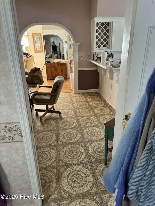 home office featuring arched walkways and light tile patterned floors