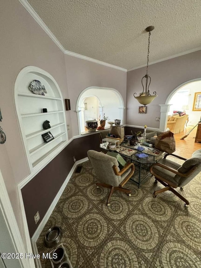 sitting room with arched walkways, wood finished floors, a textured ceiling, crown molding, and built in shelves