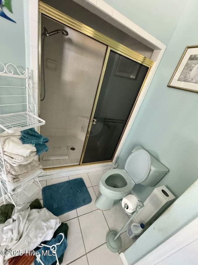 full bath featuring toilet, a shower stall, and tile patterned floors