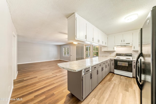 kitchen with light wood-style flooring, under cabinet range hood, freestanding refrigerator, white electric stove, and a peninsula