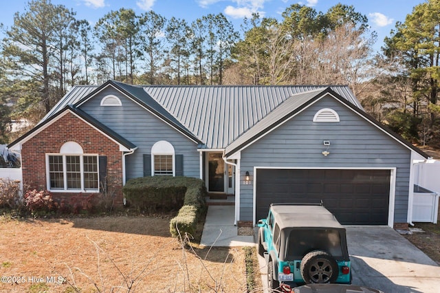 ranch-style house with an attached garage, driveway, metal roof, and brick siding