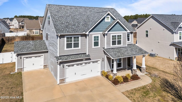 view of front facade with driveway, a residential view, fence, and a front lawn