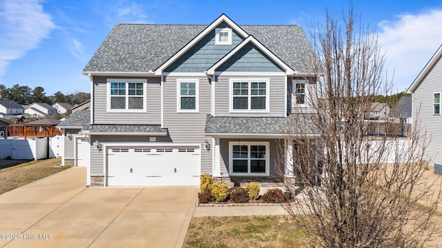 craftsman inspired home with concrete driveway, a shingled roof, stone siding, and fence