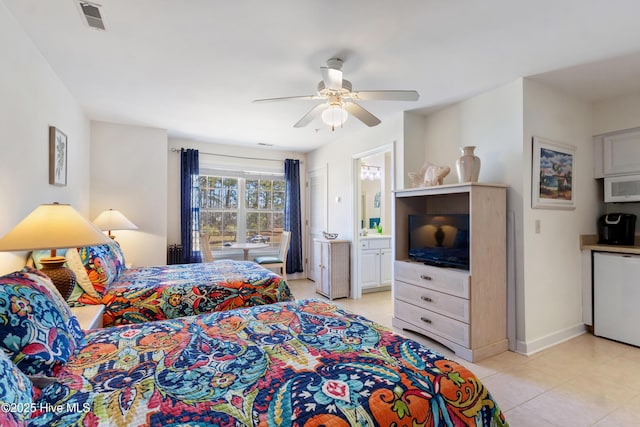 bedroom with baseboards, connected bathroom, visible vents, and a ceiling fan