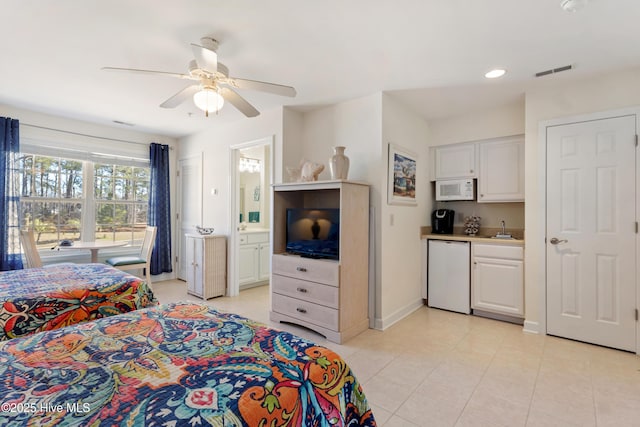 bedroom with baseboards, visible vents, ceiling fan, ensuite bathroom, and a sink